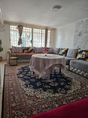 a living room with a couch and a table at Floor Villa rent in El Harhoura