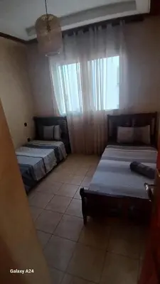 a bedroom with two beds and a window at Résidence yassine in Rabat