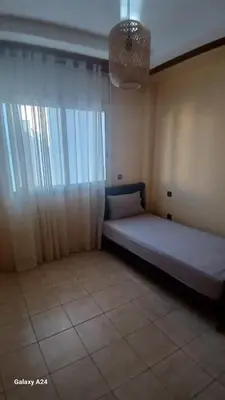 a bed in a room with a large window at Résidence yassine in Rabat