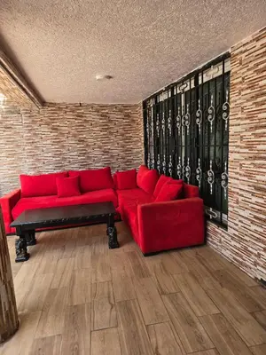 a red couch in a room with a brick wall at Appartement villa in Temara