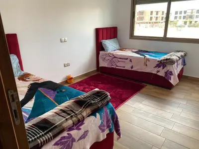 a room with two beds and a window at Blue Beach in Sidi Rahal