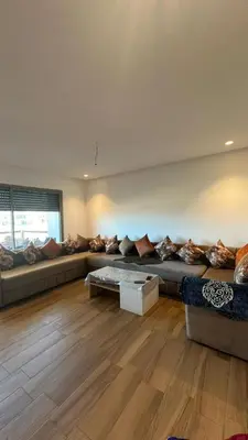 a living room with a large couch with pillows at Blue Beach in Sidi Rahal