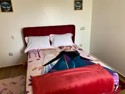 a bed with a picture of a woman on it at Blue Beach in Sidi Rahal