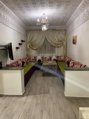 a living room with a large couch and a television at الدروة in Derroua