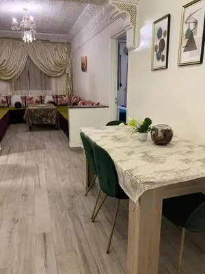 a room with a table and chairs and a bedroom at الدروة in Derroua