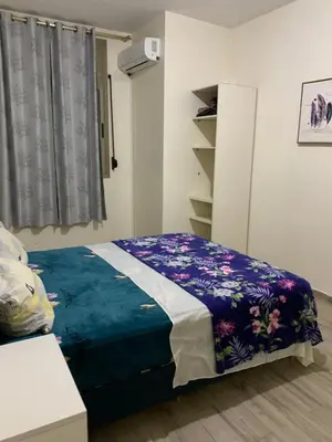 a bedroom with a bed with a blue blanket at الدروة in Derroua