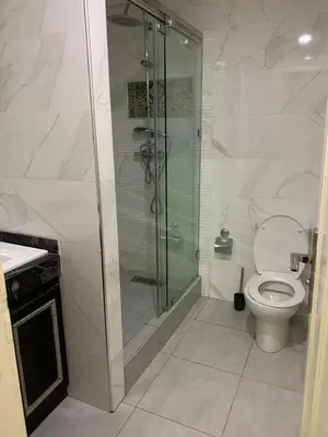 a bathroom with a toilet and a glass shower at الدروة in Derroua