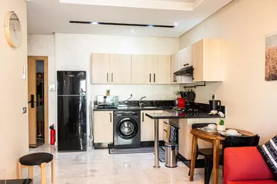 a kitchen with a stove and a refrigerator at VIVASTAY Casablanca - Ocean Park Sunset Escape beach front with swimming pool in Aïn Harrouda