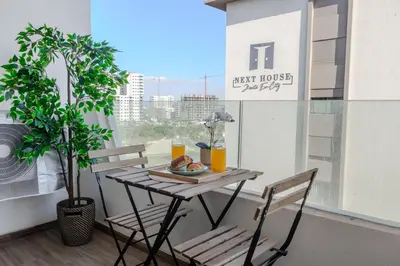 a table with a plate of food on a balcony at VIVASTAY Casablanca - Ocean Park Sunset Escape beach front with swimming pool in Aïn Harrouda
