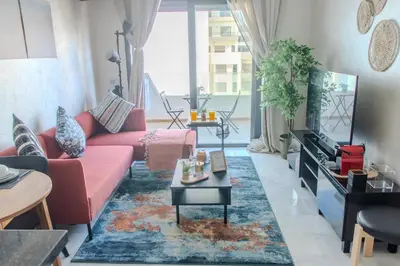 a living room with a pink couch and a rug at VIVASTAY Casablanca - Ocean Park Sunset Escape beach front with swimming pool in Aïn Harrouda