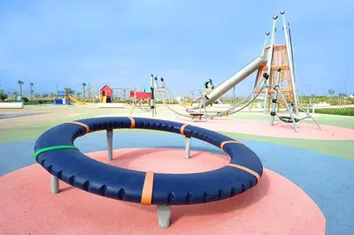 a playground with a blue tube in a park at VIVASTAY Casablanca - Ocean Park Sunset Escape beach front with swimming pool in Aïn Harrouda