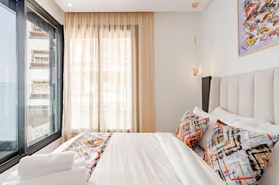 a bedroom with a white bed and a window at 2 - Bourgogne City Escape in Casablanca