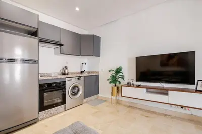 a kitchen with stainless steel appliances and a tv at 2 - Bourgogne City Escape in Casablanca