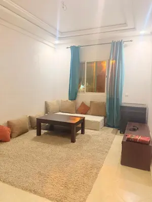 a living room with a couch and a table at Appartement Sidi Rehal beach in Sidi Rahal