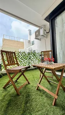 a wooden table and a wooden chair and a wooden table and bench at Urban Apartment 2 Mars - By AppartAli in Casablanca