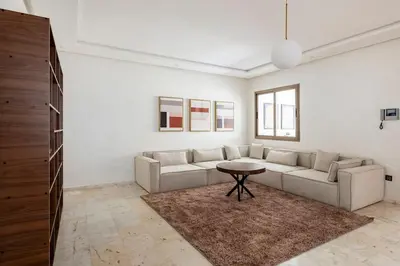 a living room with a couch and a table at Appartement neuf et moderne à l'Agdal, 2 chambres in Rabat