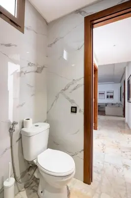 a white bathroom with a toilet in a room at Appartement neuf et moderne à l'Agdal, 2 chambres in Rabat