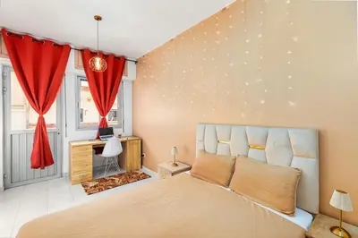 a bedroom with a large bed with a red curtain at Bright apartment Maarif, 2 bedrooms, Wi-Fi, AC in Casablanca