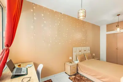 a bedroom with a bed and a desk with a laptop at Bright apartment Maarif, 2 bedrooms, Wi-Fi, AC in Casablanca