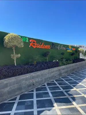a sign for a restaurant with trees on a wall at Résidence Beach Land El Mansouria in Mohammedia