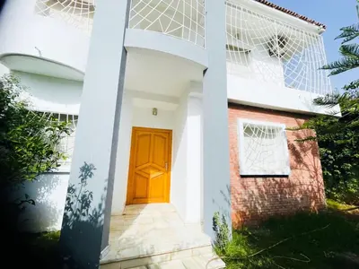 a house with a wooden door and a window at Stunning Sunny Villa, near airport in Derroua