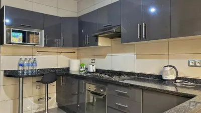 a kitchen with stainless steel appliances and black cabinets at Marrakech atmosphere in Casablanca in Casablanca