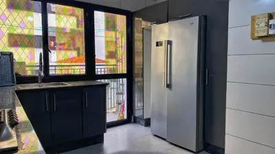 a kitchen with a stainless steel refrigerator and a window at Marrakech atmosphere in Casablanca in Casablanca