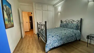 a bedroom with a bed with a blue and white comforter at Marrakech atmosphere in Casablanca in Casablanca