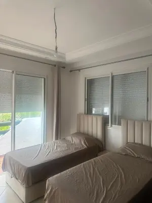 two beds in a bedroom with a window at New and cosy appt for rent in Sidi Rahal