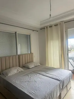 a large bed in a bedroom with windows at New and cosy appt for rent in Sidi Rahal