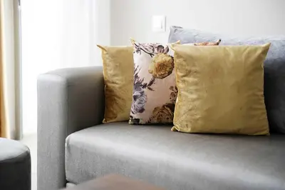 a gray couch with pillows on it in a living room at Comfortable Getaway Near the Beach in Dar Bouazza