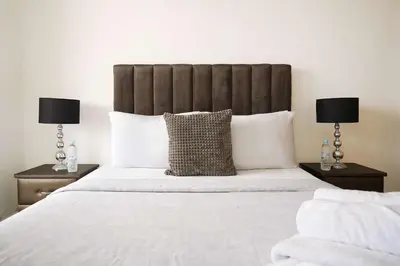 a bedroom with a large white bed with two lamps at Comfortable Getaway Near the Beach in Dar Bouazza
