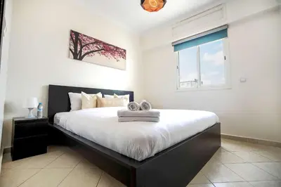 a bedroom with a black and white bed and a window at Cozy Apartment in the Heart of Bouznika in Bouznika