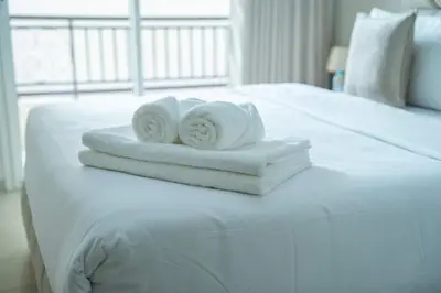 two towels sitting on top of a white bed at Appartement Élégant au Cœur de Central Park in Mohammedia