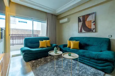 a living room with two blue couches and a table at Appartement Élégant au Cœur de Central Park in Mohammedia