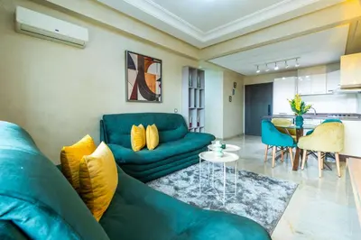 a living room with a blue couch and a table at Appartement Élégant au Cœur de Central Park in Mohammedia