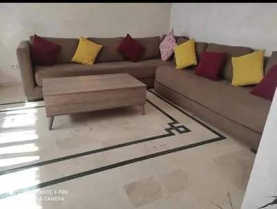 a living room with a brown couch with colorful pillows at اقامة فال دانفا in Casablanca