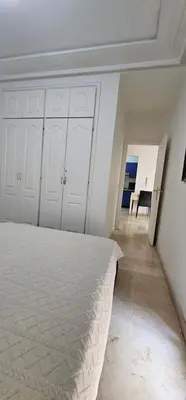 a white bedroom with a bed and a table at اقامة فال دانفا in Casablanca
