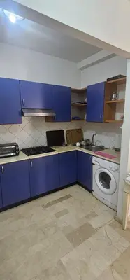 a kitchen with blue cabinets and a washing machine at اقامة فال دانفا in Casablanca