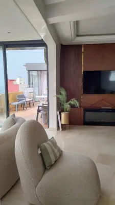 a living room with a couch and a flat screen tv at Spacious Apartment with Panoramic Ocean Views in Casablanca