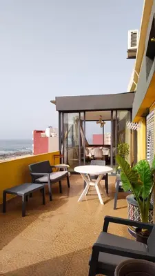 a patio with a table and benches and the ocean at Spacious Apartment with Panoramic Ocean Views in Casablanca
