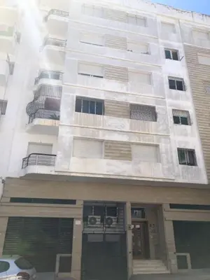 a tall white building with a car parked in front of it at Serenity in Rabat's downtown in Rabat