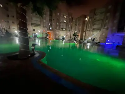 a swimming pool in a city at night at Appartement 2 chambres a coucher dans un residence securise au centre Mohamadia in Mohammedia