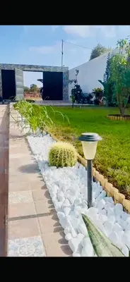 a garden with white rocks and a street light at Belle villa spacieuse et calme avec piscine à 7min de la plage en voiture in Tamaris