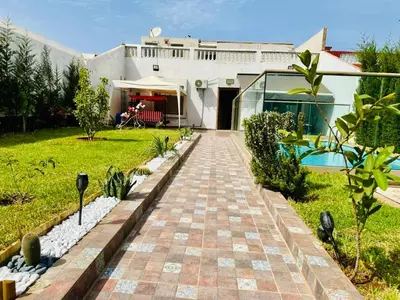 a house with a brick walkway in front of a yard at Belle villa spacieuse et calme avec piscine à 7min de la plage en voiture in Tamaris