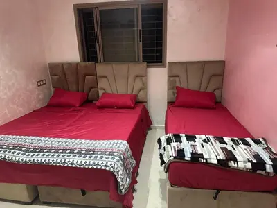 two beds in a pink room with red pillows at Belle maison avec piscine à 7 min de la plage en voiture in Dar Bouazza