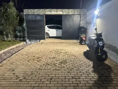 a motorcycle parked in front of a garage at Belle maison avec piscine à 7 min de la plage en voiture in Dar Bouazza