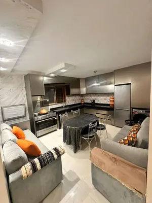 a living room with a table and a kitchen at Belle maison avec piscine à 7 min de la plage en voiture in Dar Bouazza