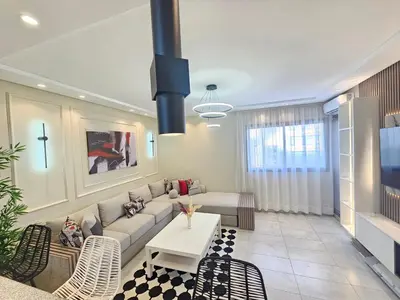 a living room with a couch and a table and chairs at Appartement El Mansouria Séjour Luxueux Plage & vue Piscine in Mansouria