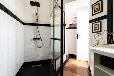 a bathroom with a shower with black and white tiles at Assayag Art Deco - 1930 in Casablanca